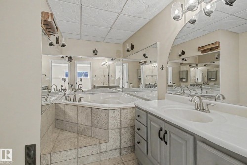 Bathroom featuring a dual vanity with white countertops and brushed nickel fixtures - 3903 32 Street, Edmonton, AB - Indoor Photo Showing Bathroom