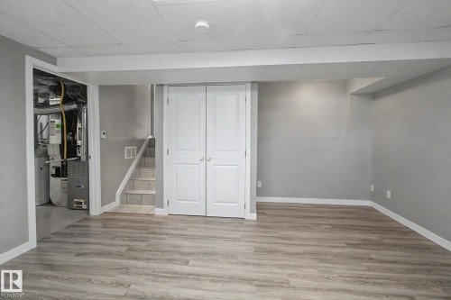 Finished room with wood-finish flooring, light gray wall paint, and white trim - 3903 32 Street, Edmonton, AB - Indoor Photo Showing Other Room