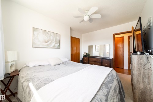 Bright room with white walls, a white ceiling fan, and warm-toned wood-finish doors and trim - 8932 154 Street, Edmonton, AB - Indoor Photo Showing Bedroom