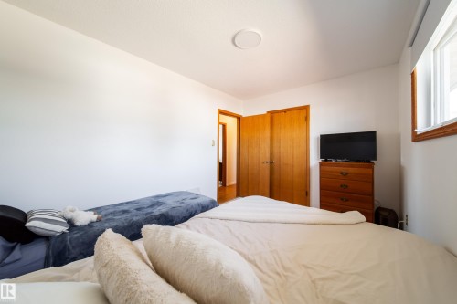 Bright interior space featuring white walls, light wood-finish doors, and a window with wood trim - 8932 154 Street, Edmonton, AB - Indoor Photo Showing Bedroom
