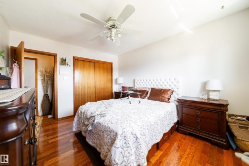 Room featuring wood-finish flooring, white walls, and a ceiling fan with integrated lighting - 8932 154 Street, Edmonton, AB - Indoor Photo Showing Bedroom