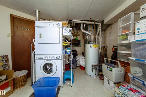 Dedicated laundry area featuring a stacked washer and dryer, adjacent to utility systems - 8932 154 Street, Edmonton, AB - Indoor Photo Showing Laundry Room