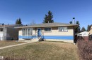 Bungalow exterior featuring a prominent bay window, stucco siding with a blue horizontal accent, and a front entry with wrought iron railings - 8932 154 Street, Edmonton, AB  - Outdoor 