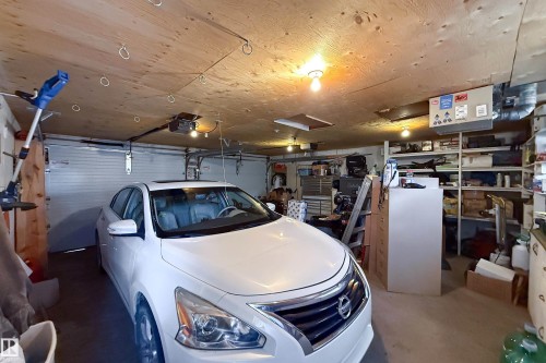 Attached garage featuring a single overhead door and wood-panel ceiling - 8932 154 Street, Edmonton, AB - Indoor Photo Showing Garage