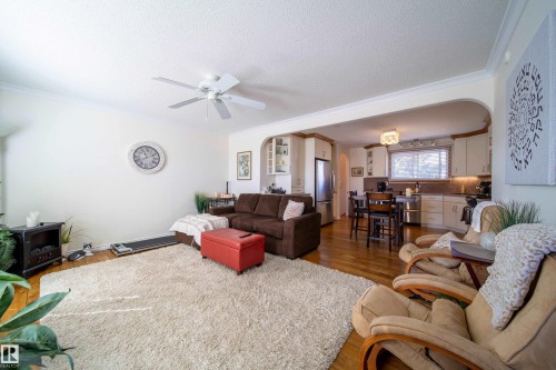 Open-concept living space featuring wood-finish flooring, a ceiling fan, and crown molding - 8932 154 Street, Edmonton, AB - Indoor Photo Showing Living Room