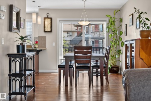 Dining area featuring wood-finish flooring and a glass patio door - 1786 Cunningham Way Sw, Edmonton, AB - Indoor Photo Showing Dining Room