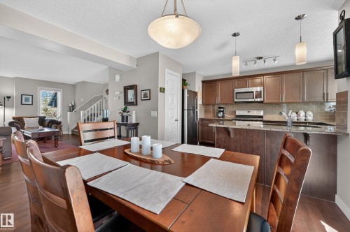 Open-concept living space featuring wood-finish flooring throughout the dining area and kitchen - 1786 Cunningham Way Sw, Edmonton, AB - Indoor