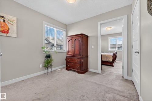 Carpeted room with neutral wall tones and a window featuring blinds - 1786 Cunningham Way Sw, Edmonton, AB - Indoor