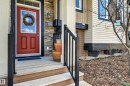 Entryway featuring a red paneled door with a glass insert, stone veneer siding, and contrasting light-toned horizontal siding - 1786 Cunningham Way Sw, Edmonton, AB  - Outdoor With Exterior 