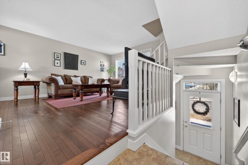 Open-concept living space featuring wood-finish flooring, neutral wall tones, and white trim - 1786 Cunningham Way Sw, Edmonton, AB - Indoor