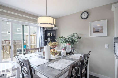 Dining area featuring a contemporary drum pendant light and direct access to an outdoor deck - 16619 14 Avenue, Edmonton, AB - Indoor Photo Showing Dining Room