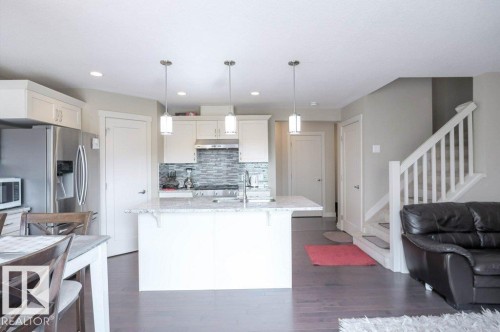 Kitchen featuring a center island, white cabinetry, and stainless steel appliances - 16619 14 Avenue, Edmonton, AB - Indoor Photo Showing Kitchen With Upgraded Kitchen