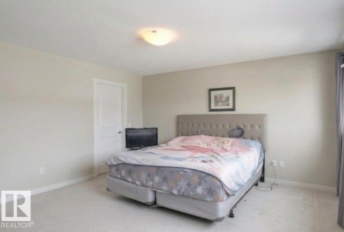 Spacious room featuring neutral tone walls, white trim, and light-colored carpet flooring - 16619 14 Avenue, Edmonton, AB - Indoor Photo Showing Bedroom