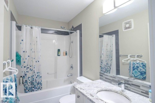 Bathroom featuring a white bathtub and shower combination with a curved shower rod - 16619 14 Avenue, Edmonton, AB - Indoor Photo Showing Bathroom