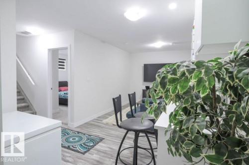 Open-concept living space featuring wood-finish flooring and recessed lighting - 16619 14 Avenue, Edmonton, AB - Indoor Photo Showing Other Room