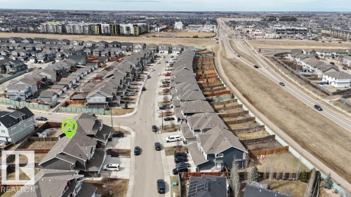 Aerial perspective showcasing a residential community with a high-speed roadway and commercial buildings in the background - 16619 14 Avenue, Edmonton, AB - Outdoor With View