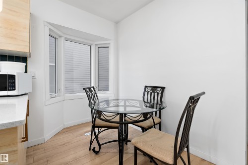 Breakfast nook featuring a bay window, light wood-finish flooring, and white walls - 11919 96 Street, Edmonton, AB - Indoor Photo Showing Dining Room