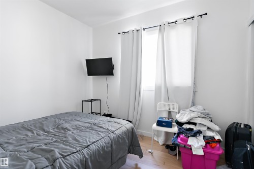 Bedroom featuring light-colored walls and wood-finish flooring - 11919 96 Street, Edmonton, AB - Indoor Photo Showing Bedroom