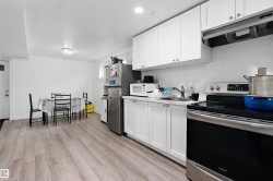 Bright kitchen featuring white shaker cabinetry, stainless steel range, white subway tile backsplash, and light wood-finish flooring - 