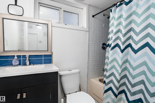 Bathroom featuring a dark wood-finish vanity with a white countertop and rectangular basin - 11919 96 Street, Edmonton, AB - Indoor Photo Showing Bathroom
