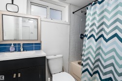 Bathroom featuring a dark wood-finish vanity with a white countertop and rectangular basin - 