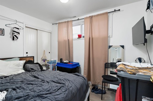 White walls and light wood-finish flooring provide a neutral backdrop - 11919 96 Street, Edmonton, AB - Indoor Photo Showing Bedroom
