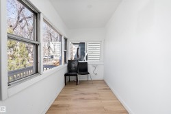 Bright sunroom featuring multiple windows, wood-finish flooring, white walls, and recessed lighting - 