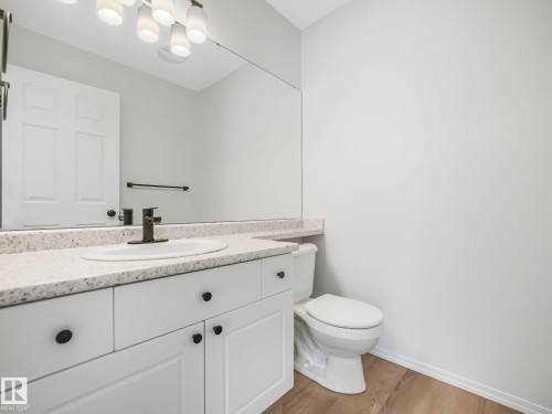Bathroom featuring a white vanity with black hardware, a light-colored countertop, and a toilet - 14 15128 22 Street, Edmonton, AB - Indoor Photo Showing Bathroom