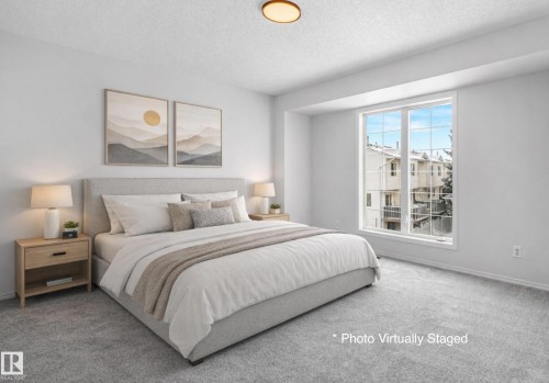Bedroom featuring light gray carpeting, a large window, and recessed lighting - 14 15128 22 Street, Edmonton, AB - Indoor Photo Showing Bedroom