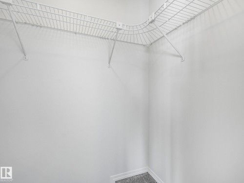 The property features a closet with white wire shelving and a light gray carpeted floor - 14 15128 22 Street, Edmonton, AB - Indoor With Storage