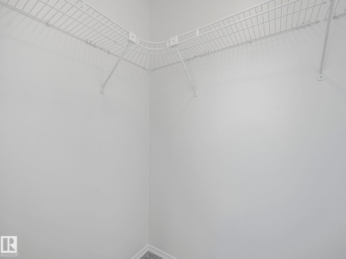 The property includes a walk-in closet with white wire shelving - 14 15128 22 Street, Edmonton, AB - Indoor Photo Showing Other Room