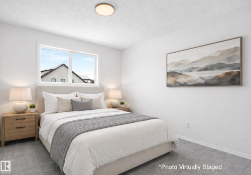 This bedroom features white walls, carpet flooring, and a window providing natural light. Photo Virtually Staged. - 14 15128 22 Street, Edmonton, AB - Indoor Photo Showing Bedroom