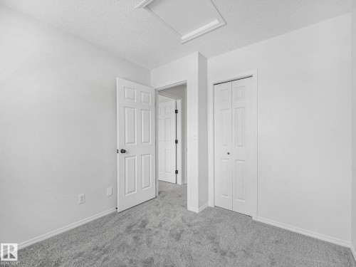 This room features neutral-toned carpet flooring and white walls, offering a versatile canvas for personalization - 14 15128 22 Street, Edmonton, AB - Indoor Photo Showing Other Room