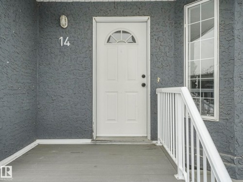Exterior entrance with a white panel door, an arched window detail, and a vertical window - 14 15128 22 Street, Edmonton, AB - Outdoor With Exterior
