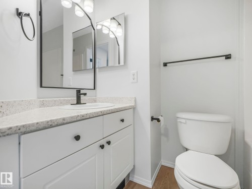 Bathroom featuring a white vanity with dark hardware, a light-colored countertop, and a toilet - 14 15128 22 Street, Edmonton, AB - Indoor Photo Showing Bathroom
