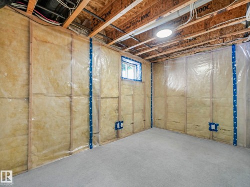 The property features an unfinished basement with exposed wooden joists and a visible window - 14 15128 22 Street, Edmonton, AB - Indoor Photo Showing Basement