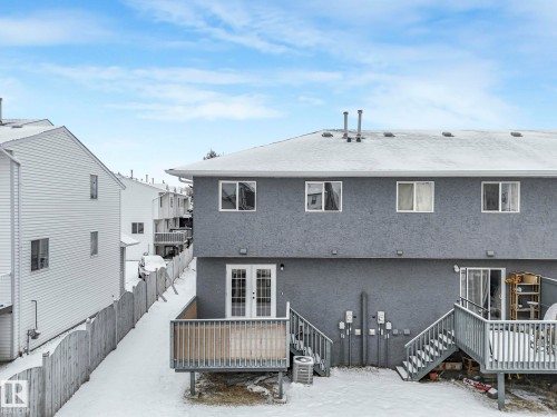 The property features a private deck with stairs leading to the yard, and a patio with a sliding glass door - 14 15128 22 Street, Edmonton, AB - Outdoor With Deck Patio Veranda