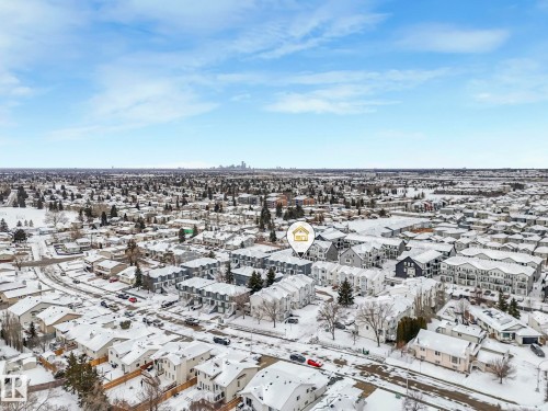 Aerial view of the neighborhood, showcasing residential properties under a clear blue sky, with a city skyline visible in the distance - 14 15128 22 Street, Edmonton, AB - Outdoor With View