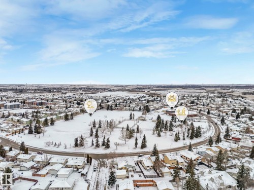 Aerial view of the surrounding neighbourhood with a large open field, numerous trees, and residential properties - 14 15128 22 Street, Edmonton, AB - Outdoor With View