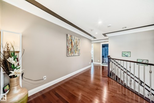 This hallway features rich wood flooring, crown molding, and recessed lighting - 3220 151 Avenue, Edmonton, AB - Indoor Photo Showing Other Room