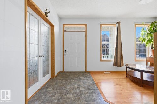 Entryway featuring two-tone flooring with stone-look tile and wood-finish planks - 9904 144 Avenue, Edmonton, AB - Indoor Photo Showing Other Room