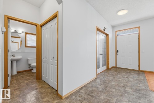 Entryway featuring textured flooring, a white front door with transom window, and a flush-mount ceiling light - 9904 144 Avenue, Edmonton, AB - Indoor Photo Showing Other Room