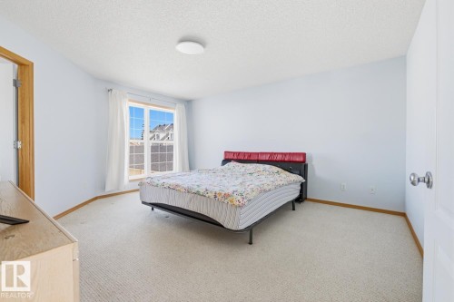 Spacious room featuring light blue walls, neutral carpet flooring, and white trim - 9904 144 Avenue, Edmonton, AB - Indoor Photo Showing Bedroom