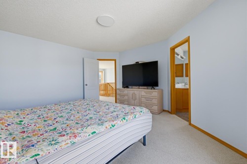 Spacious bedroom featuring light blue walls, soft carpet flooring, and a built-in ceiling speaker - 9904 144 Avenue, Edmonton, AB - Indoor Photo Showing Bedroom