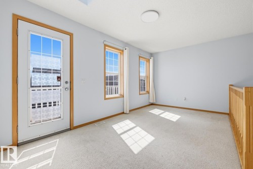 Neutral-toned carpeted room with light blue walls and natural wood trim - 9904 144 Avenue, Edmonton, AB - Indoor Photo Showing Other Room