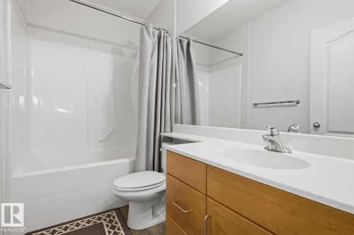Bathroom featuring a light wood vanity with a white countertop and integrated sink - 9904 144 Avenue, Edmonton, AB - Indoor Photo Showing Bathroom
