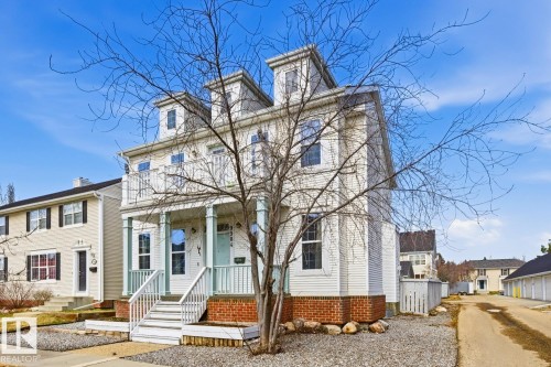 Multi-story residence featuring dormer windows, a balcony, and a covered porch with white columns and railings - 9904 144 Avenue, Edmonton, AB - Outdoor With Facade