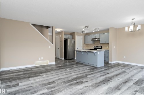 Spacious open-concept living area featuring wood-finish flooring - 3314 9 Street Nw, Edmonton, AB - Indoor Photo Showing Kitchen