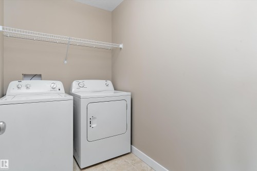 Dedicated laundry area featuring a neutral wall color, white wire shelving, and light-toned floor tile - 3314 9 Street Nw, Edmonton, AB - Indoor Photo Showing Laundry Room
