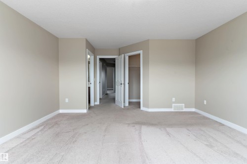 Spacious carpeted room featuring neutral wall paint, white trim, and a built-in closet - 3314 9 Street Nw, Edmonton, AB - Indoor Photo Showing Other Room